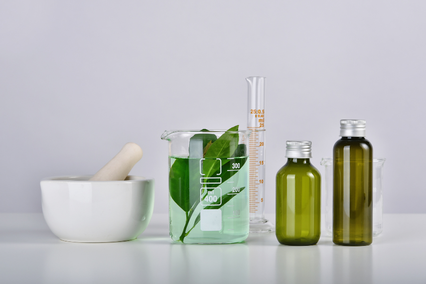 Laboratory glassware with natural extracts and liquids, symbolizing cosmetic emulsifiers in B2B specialty chemicals