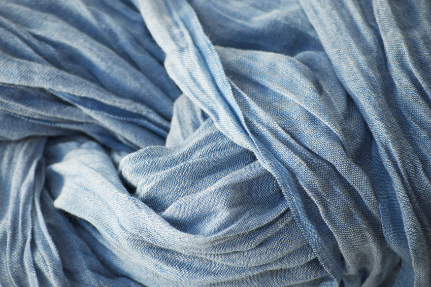 Close-up of light blue soft fabric with folds and texture, symbolizing textiles, fabric suppliers, and sustainable fashion