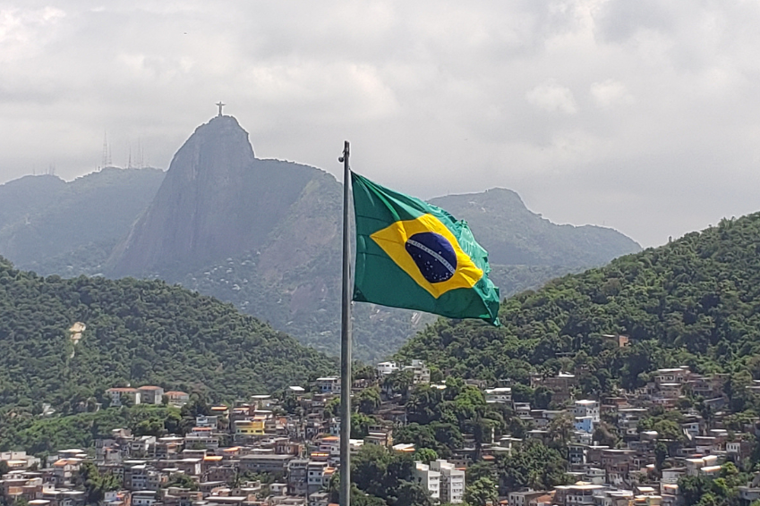 Brazilian flag waving with Christ the Redeemer in the background, representing SBR International GmbH’s partnerships in Brazil