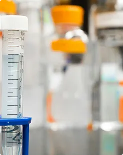 Laboratory burette with orange liquid, representing pharmaceutical research and innovative excipient solutions from SBR International GmbH