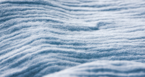 Close-up of light blue textured fabric with ridges, symbolizing textile pre-treatment chemicals and fabric finishing