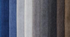 Fabric swatches in gradient colors from dark blue to beige and brown, symbolizing textile design, fabric options, and upholstery