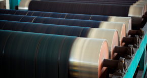 Industrial rollers in a manufacturing facility, symbolizing process efficiency, specialty chemicals, and material coating