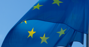 European Union flag waving in the wind, symbolizing unity, regulations, and compliance in Europe
